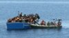 Members of an Italian Navy unit, in the boat at right, rescue migrants in the Mediterranean Sea, May 3, 2015.