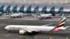 An Emirates plane taxis to a gate at Dubai International Airport at Dubai International Airport in Dubai, United Arab Emirates. Emirates Airline, the world's biggest international air carrier by traffic, said Wednesday it is cutting flights to five U.S. cities because of a drop in demand since President Donald Trump sought to curb immigration from several Muslim-majority countries and imposed restrictions on passengers carrying electronic devices on flights to the United States, April 19, 2017. 