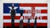 FILE - A woman and two children walk past a mural in Monrovia, Liberia, Nov. 10, 2011. The United Nations on Wednesday lifted the last international sanctions against Liberia. 