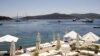 A woman sunbathes on a near-deserted deck as luxury boats are seen anchored off the beach front of a hotel in Golturkbuku, near the resort town of Bodrum on the southwest Aegean coast of Turkey, July 17, 2007. 