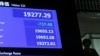 A man is seen behind an electronic board showing the Nikkei average after the New Year's opening ceremony at the Tokyo Stock Exchange, held to wish for the success of Japan's stock market, in Tokyo, Jan. 4, 2019. 