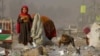 FILE - Afghan refugees girls collect recycle-able goods from a garbage to sell and earn living for their families in Peshawar, Pakistan, Feb. 5, 2016.