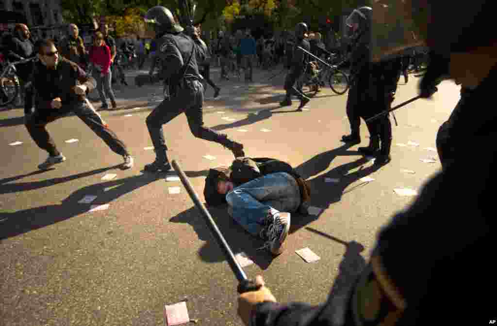 A protestor lies on the ground during clashes with riot police in Madrid, Spain, November 14, 2012.