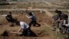 Relatives and friends dig the graves of two civilians killed during fighting between Iraqi security forces and Islamic State militants on the western side of Mosul, Iraq, March 25, 2017.
