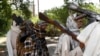 FILE - In this July 31, 2011 file photo, Taliban fighters hold their heavy and light weapons before surrendering them to Afghan authorities in Jalalabad, east of Kabul, Afghanistan. 