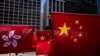 Pedestrians walk near Hong Kong and Chinese flags in Hong Kong on June 29, 2023, ahead of the 26th anniversary of the city’s handover from Britain to China on July 1. (Photo by ISAAC LAWRENCE / AFP)