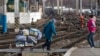 A woman pulls a loaded trolley across the lines at the main railway station in Simferopol, Ukraine, Friday, March 14, 2014. 