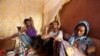 FILE - Illegal immigrants from Ethiopia attempting to cross into Yemen smoke shisha in their makeshift shelter in Bosasso, northern Somalia's breakaway Puntland region, Apr. 14, 2015. 