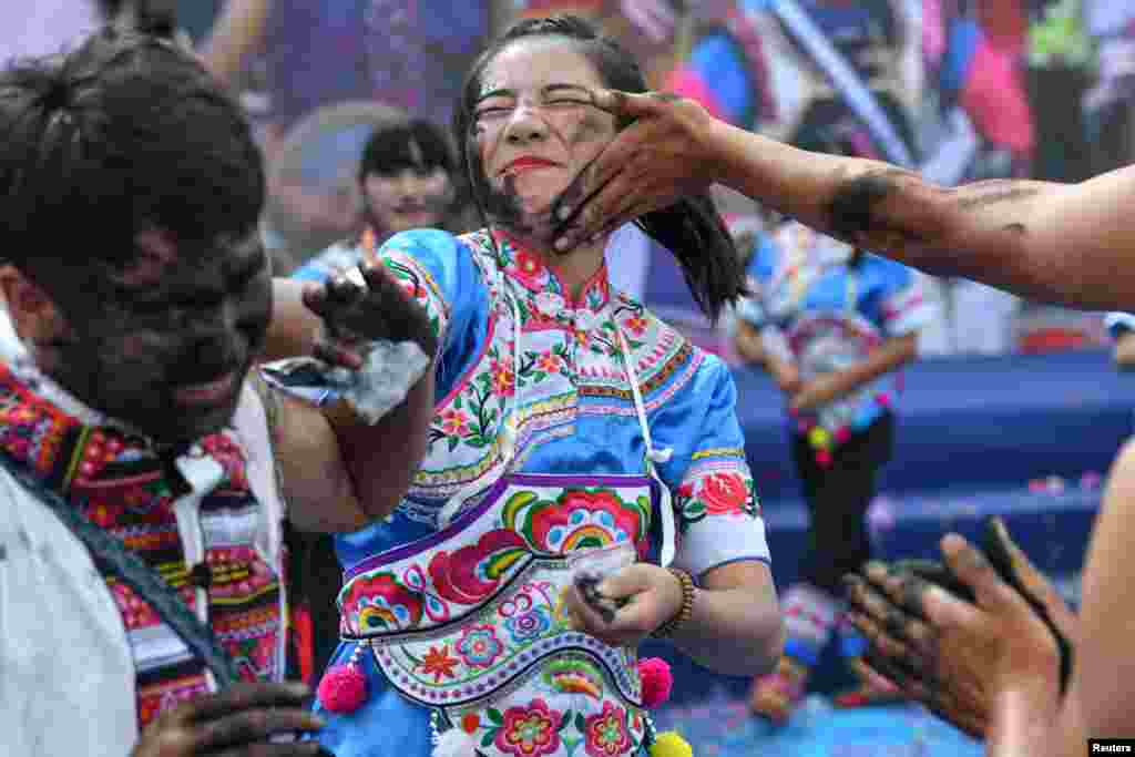 ប្រជាជនកំពុងប៉ាតផេះខ្មៅលើមុខគ្នាទៅវិញទៅមកដើម្បីឲ្យមានលាភសំណាងក្នុងទិវាប្រពៃណីរបស់ក្រុមជនជាតិ Yi នៅទីក្រុង Qiubei ខេត្ត Yunnan ប្រទេសចិន។