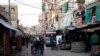 FILE - Shoppers walk along the main street of the Shatila Palestinian refugee camp on the outskirts of Beirut.