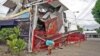 A resident inspects a building collapsed during an earthquake in Cebu city, central Philippines, Oct. 15, 2013. 