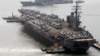 FILE - The USS Ronald Reagan anchors as a U.S. Aegis combat vessel passes at Busan port for joint military exercises in Busan, South Korea, March 22, 2007. The Reagan is now part of an annual bilateral training exercise with Japanese naval forces.