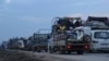 Truckloads of civilians flee a Syrian military offensive in Idlib province on the main road near Hazano, Syria, Dec. 24, 2019. 