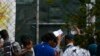FILE - Migrants and refugees wait in a queue for the doctor at the Moria refugee camp on the northeastern Aegean island of Lesbos, Greece, Sept. 25, 2019. 
