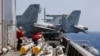 FILE - U.S. Navy crewmen from the U.S. Navy aircraft carrier USS Carl Vinson (CVN 70) prepare to load missiles to F-18 fighter jets prior to a routine patrol off the South China Sea, March 3, 2017. 