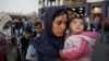 FILE - Syrian refugees disembark from a Greek ferry after arriving in the port of Piraeus near Athens, June 14, 2015.