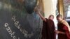Two monks touch the large bronze gong at the Maha Muni Buddha Temple in Mandalay. (Z. Aung/VOA)