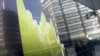 FILE - Pedestrians are reflected in an electronic stock chart showing Japan's Nikkei 225 at a securities firm in Tokyo, Feb. 9, 2016.