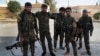 FILE - In this July 22, 2017, photo, Arab and Kurdish fighters with the U.S.-backed Syrian Democratic Forces (SDF), pose for a picture as they prepare to move to the front line to battle against the Islamic State militants, in Raqqa, northeast Syria.
