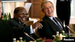 Le président tanzanien Benjamin Mkapa (à g.) rit avec le président américain George W. Bush lors du sommet du G8 le 8 juillet 2005 à l'hôtel Gleneagles à Auchterarder, en Écosse. REUTERS/White House/Eric Draper 