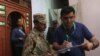 A census enumerator (R) along with a Pakistan Army soldier notes details outside a house