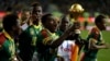 Les joueurs camerounais courent avec la coupe dans leurs mains, au stade de l'Amitié, à Libreville, le 5 février 2017.