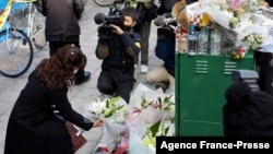 A woman offers flowers for victims in front of an office building, where a fire broke out the previous day, in Osaka, Japan, on Dec. 18, 2021. 