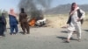FILE - Men gather near a burning vehicle hit by a U.S. drone strike in Baluchistan province, Pakistan, May 21, 2016. The strike killed Afghan Taliban leader Akhtar Mansoor, and strained U.S.-Pakistani relations, a Pakistani official says.