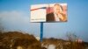 FILE - A partially damaged billboard with a portrait of Russian President Vladimir Putin is seen on a roadside near Simferopol, Crimea, Jan. 24, 2016. The billboard reads: "Crimea. Russia. Forever."