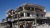 FILE - The remains of buildings line a street that was damaged last summer during fighting between U.S.-backed Syrian Democratic Forces fighters and Islamic State militants, in Raqqa, Syria, April 5, 2018. 