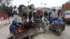 FILE - Afghan women and children sit in a cart pushed by a man as they enter Afghanistan through Pakistan's border crossing in Torkham, east of Kabul, Afghanistan, March. 11, 2015.