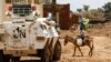 Un garçon conduit un âne devant un blindé de la mission des Nations unies et de l'Union africaine au Darfour (MINUAD) dans la ville de Golo, au Darfour, Soudan, le 19 juin 2017. AFP PHOTO / ASHRAF SHAZLY