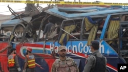 Pakistani security personnel examine a bus following a bomb blast in Peshawar, Pakistan, Wednesday, March 16, 2016.