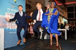 FILE - Britain's Prime Minister Boris Johnson, center, visits the Pavegen stand, a company that converts footsteps into energy, at the Innovation Zone during the UK Africa Investment Summit in London, Jan. 20, 2020.