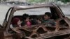 Children play inside the wreckage of a burnt vehicle at al-Myassar neighborhood in Aleppo, Syria, Feb. 16, 2015. 