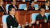 Cambodian Prime Minister Hun Sen, left, sits inside the session hall of the National Assembly with lawmakers from his Cambodian People's Party, in Phnom Penh, Cambodia, Sept. 24, 2013.