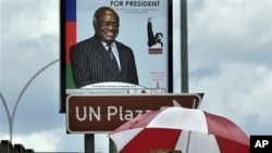 People walk under an election poster of Hifikepunye Pohamba in Katatura, outside Windhoek, (file photo)