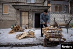 Hennadiy Batsak, de 63 años, recoge madera que utiliza para calentar su apartamento que carece de calefacción, agua y gas en la ciudad fronteriza de Lyman, en medio del ataque de Rusia a Ucrania, el 14 de diciembre de 2023. REUTERS/Thomas Peter