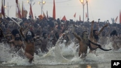 Indian Hindu holy men run naked into the water at Sangam, the confluence of the rivers Ganges, Yamuna and mythical Saraswati, during the royal bath at the start of the Kumbh Mela in Allahabad, India, Janaury 14, 2013.