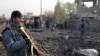 Afghan security members inspect the site of a suicide car bombing at Surkh Rud district in Nangarhar province, east of Kabul, Afghanistan, Dec. 7, 2015.