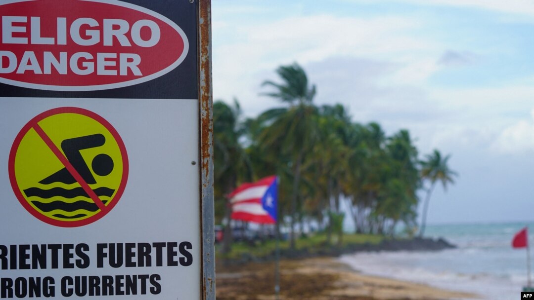 Un cartel de advertencia que dice "Peligro, no nadar" se ve en la playa de Luquillo, Puerto Rico, el 13 de agosto de 2024, mientras se acerca la tormenta tropical Ernesto.