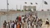 FILE - People cross the border coming from Afghanistan to Pakistan, at the border town of Chaman. Pakistan will reopen the Chaman border crossing for routine traffic on Sept. 1, 2016, after days of closure, officials said.