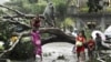 Residents saw an uprooted tree to clear the road after Typhoon Bopha hit Tagum City, southern Philippines December 4, 2012.