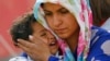 A Syrian Kurdish refugee woman and her child wait after crossing the Turkish-Syrian border near the southeastern town of Suruc in Sanliurfa province, Sept. 27, 2014.