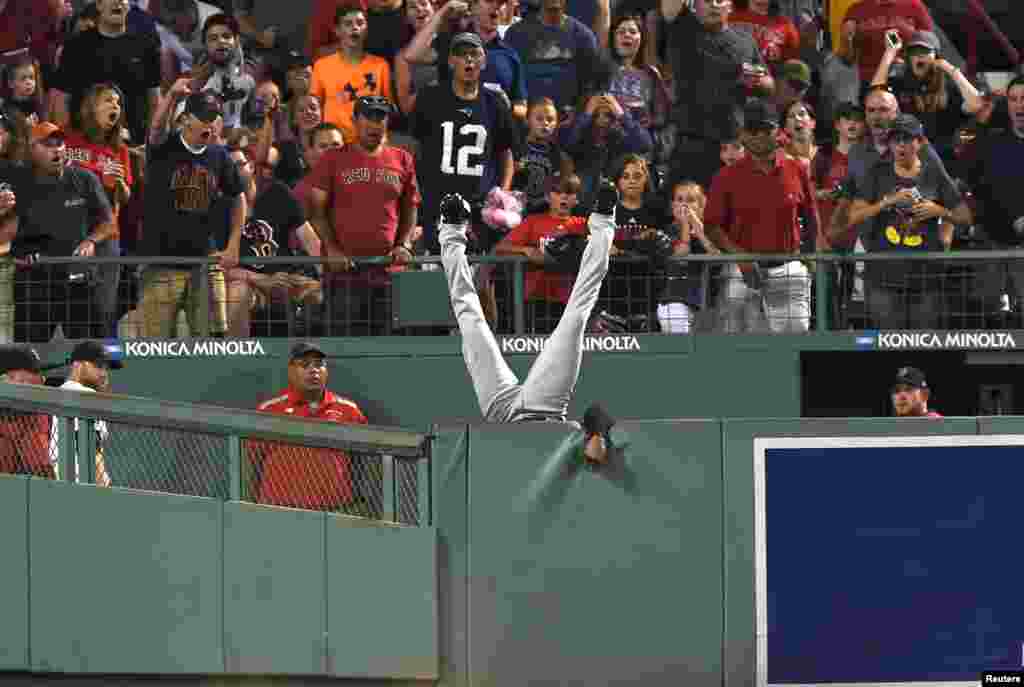 កីឡាករនៃមជ្ឈមណ្ឌល Cleveland Indians លោក Austin Jackson អាយុ២៦ឆ្នាំធ្លាក់ពីជញ្ជាំងបន្ទាប់ពីព្យាយាមឆក់បាល់ពី Hanley Ramirez (មិននៅក្នុងរូបភាព) នៃក្រុម Boston Red Soxក្នុងការប្រកួតជុំទី០៥ នៅក្នុងកីឡដ្ឋាន Fenway Park ទីក្រុង Boston រដ្ឋ Massachusetts។