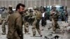 FILE - US forces and Afghan security inspect the site after a suicide bombing attack near Kabul's international airport in Kabul, Afghanistan, May 17, 2015. 