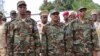 FILE - Somalia's Defense Minister Abdirashid Abdulahi Mohamed, left, watches a military unit alongside President Mohamed Abdullahi Mohamed, center, and Somali Prime Minister Hassan Ali Khayre, right, during celebrations marking the 57th anniversary since Somali military was founded, in Mogadishu, April 12, 2017.