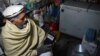 FILE - An Afghan shopkeeper listens to Islamic State Radio at his shop in Jalalabad, capital of Nangarhar province, Afghanistan, Jan. 10, 2016.