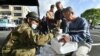 Earthquake-affected evacuees receive rice rations from Japanese Self-Defense Forces personnel at the Mashiki village office in Kumamoto prefecture, April 17, 2016. Rescuers were racing against the weather to try to find trapped survivors.