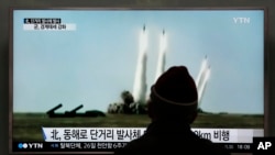 지난 21일 한국 서울역에서 지나가던 시민이 북한의 미사일 발사 시험에 관한 TV 뉴스 보도를 시청하고 있다. (자료사진)